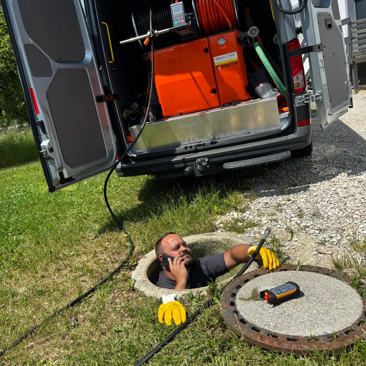 Techniker reinigt Kanal per Hochdruckspülung am Haus